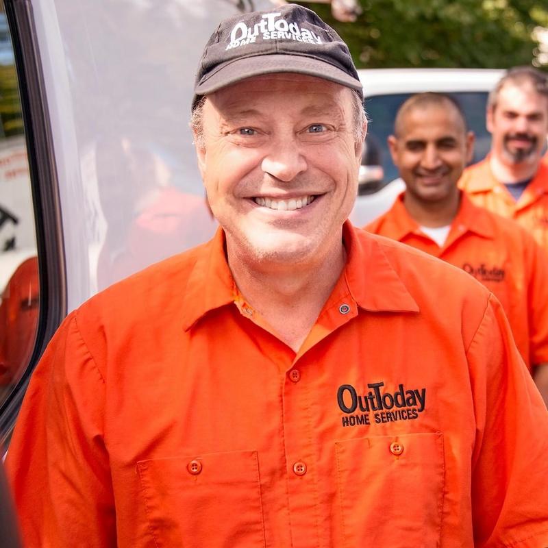 Smiling OutToday technician in an orange OutToday work shirt and cap